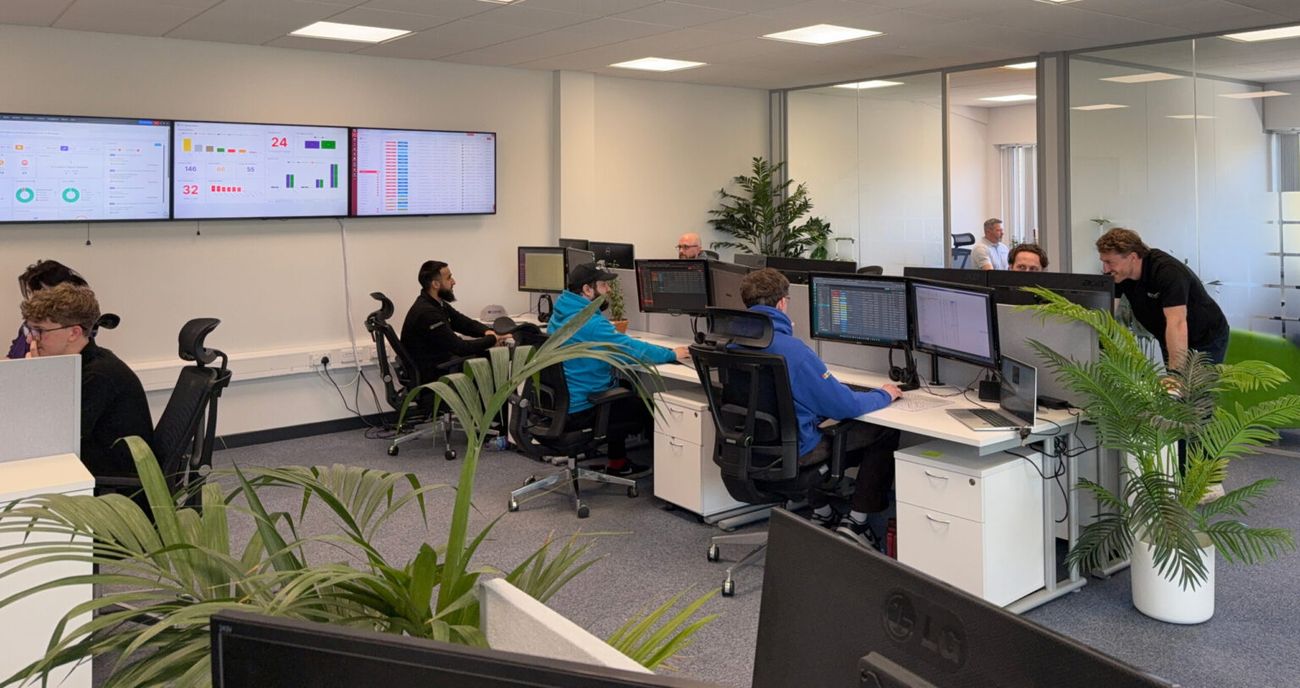 A monitoring room with wall-mounted dashboards tracking system status