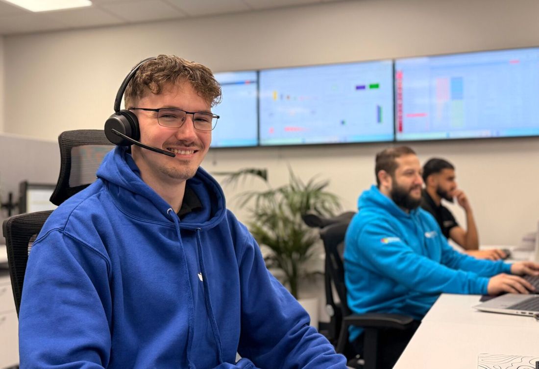A support specialist at a workstation, headset on, ready to take a call